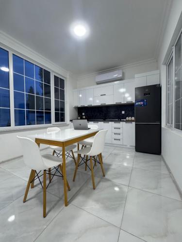 a kitchen with a table and chairs and a refrigerator at Apple Garden Guba in Quba