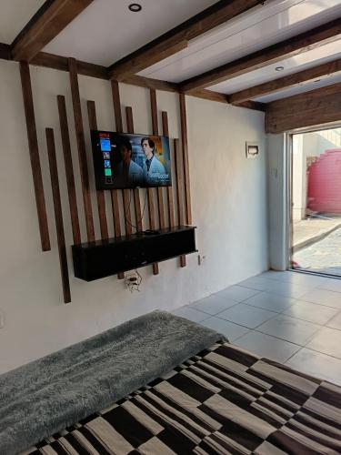 a bedroom with a flat screen tv on the wall at PMB Backpackers Lodge in Pietermaritzburg