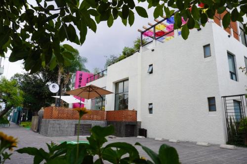 a white building with an umbrella in front of it at Hotel Consulado in Guadalajara
