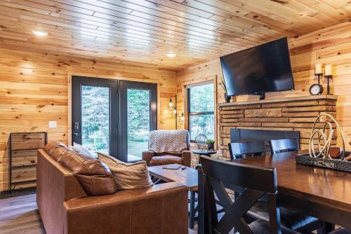 a log cabin living room with a table and a television at Adventure & Relaxation by Lake Superior in Paradise