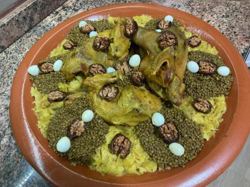 a plate of food with chicken and nuts on it at Bens White House in AÃ¯n el Ksob