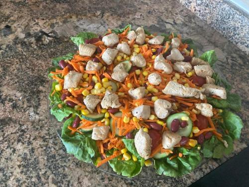 a salad with chicken and vegetables on a plate at Bens White House in AÃ¯n el Ksob