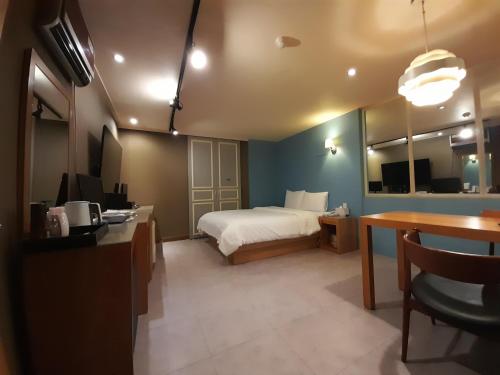 a hotel room with a bed and a desk and a table at Rosemari Hotel in Seoul