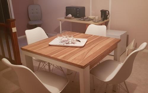 a wooden table with chairs and glasses on it at Chambres d'hôte dans une Villa 4 façades - quartier vert et boisé - 5 kms de Namur in Namur