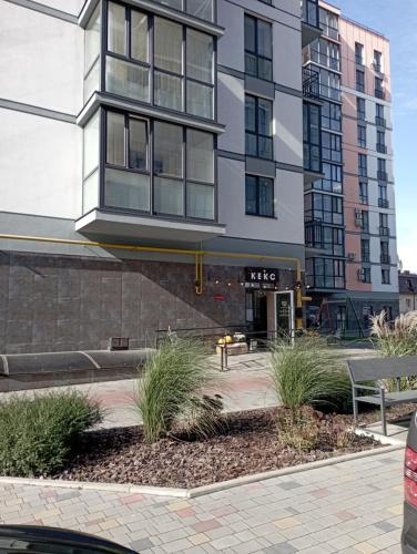 ルツカイにあるЖК Dream Town, Lutskの高い窓とその前に植物がある建物