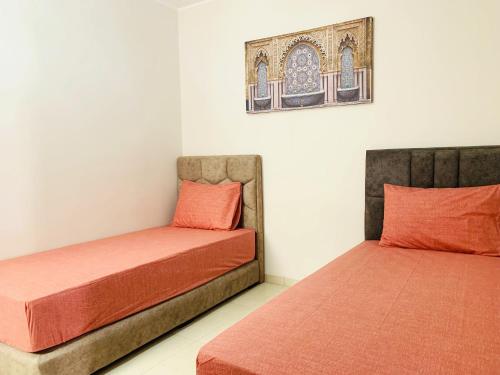 two beds sitting next to each other in a room at Sunset Eden sea view in Aourir