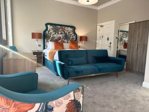a bedroom with a blue couch and a bed at The Tontine Hotel in Greenock