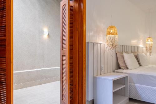 a bedroom with a bed and a bathroom with a shower at Pousada Porto Fino in Cabo Frio
