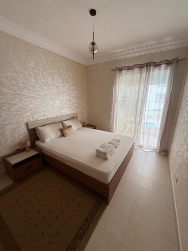a bedroom with a bed and a large window at Plage manesmann in Mohammedia