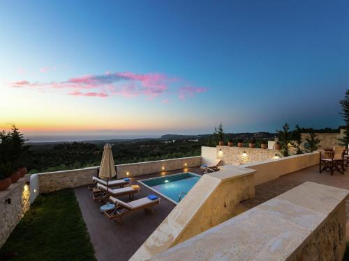 a villa with a swimming pool and a patio at New villa with private pool, privacy, near sea and Arkadi monastery on NW coast in Roúpai