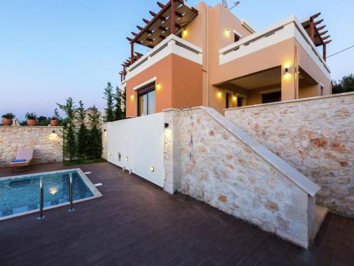 a villa with a swimming pool and a house at New villa with private pool, privacy, near sea and Arkadi monastery on NW coast in Roúpai