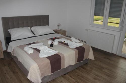 a bedroom with a bed with towels on it at Apartmani Ramonda in Teslić