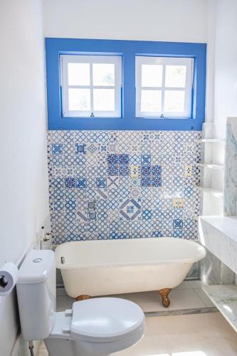 a bathroom with a white tub and a toilet at Maravilhosa Casa Mineira in Tiradentes