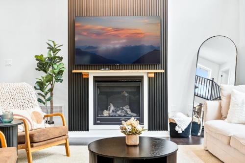 a living room with a fireplace with a tv above it at Luxe Forest Retreat HotTub, Sauna, PoolTable, View in Dwight