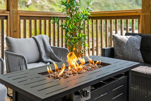 a coffee table with a fire pit on a deck at Luxe Forest Retreat HotTub, Sauna, PoolTable, View in Dwight