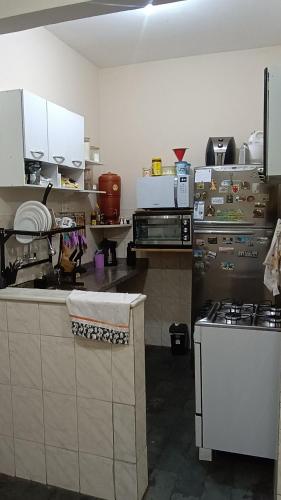 eine Küche mit weißen Schränken und einem Herd in der Unterkunft Quarto ao lado da praça da Liberdade in Belo Horizonte