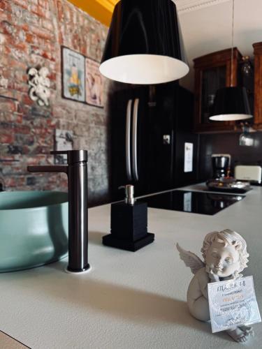 a lamp on a kitchen counter with a doll sitting on the counter at Vibrant Downtown Studio Oasis in Liepāja