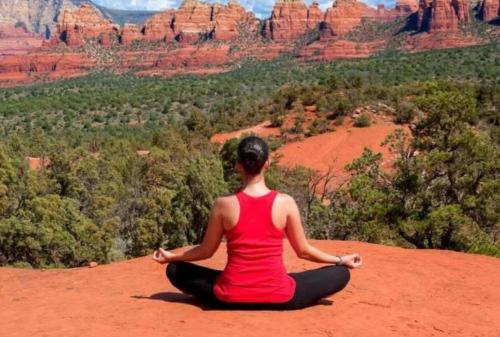 a woman sitting in a yoga pose on top of a mountain at Sedona Retreat with Hot Tub and Views for Family in Sedona