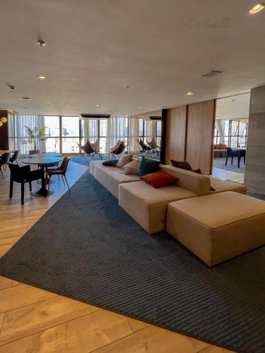 a living room with a long couch and a table at Skylux By Cris Borriello in Rio de Janeiro