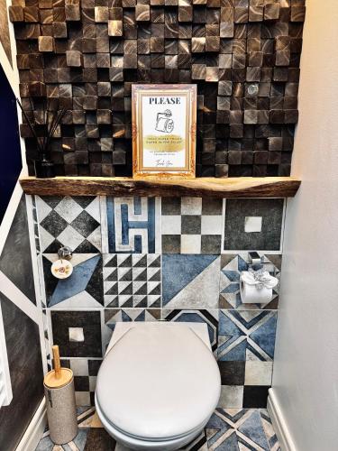 a bathroom with a toilet and a tiled floor at Vibrant Downtown Studio Oasis in Liepāja