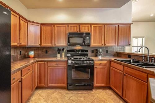 a kitchen with wooden cabinets and a black stove top oven at Sedona Retreat with Hot Tub and Views for Family in Sedona