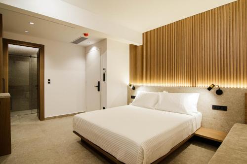 a bedroom with a large white bed and a bathroom at Thea Experience in Litochoro