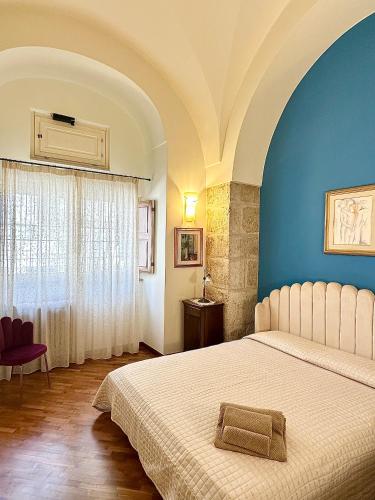 a bedroom with a bed and a blue wall at Suite Santa Caterina in Altamura
