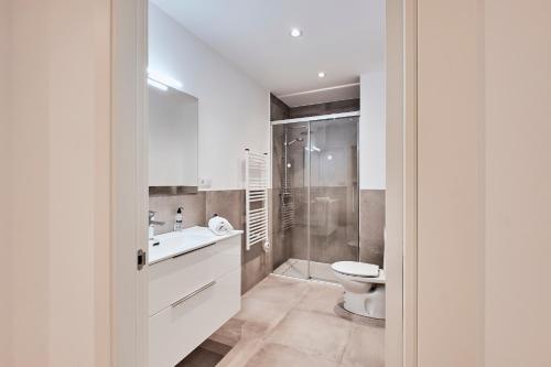 a white bathroom with a toilet and a sink at San vicente in A Coruña