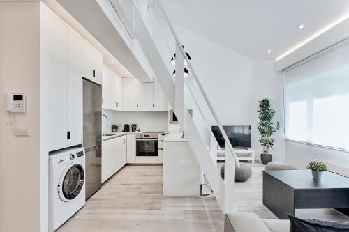 a kitchen and living room with white walls and stairs at San vicente in A Coruña