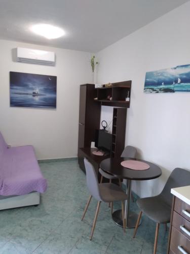 a room with a table and chairs and a bed at Apartment Hortenzija in Baška Voda