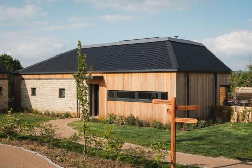a wooden building with a black roof and a sign at Horslip in Marlborough