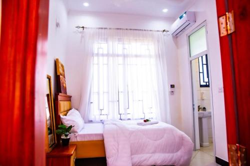 a bedroom with a white bed and a window at Warm Haven in Dar es Salaam