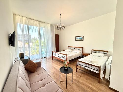 a living room with two beds and a couch at Sun Line Hotel Kobuleti in Kobuleti