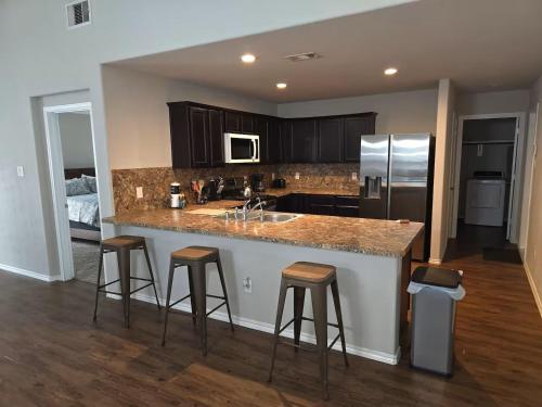 a kitchen with a large island with bar stools at Katy's five bedrooms home away from home! in Katy