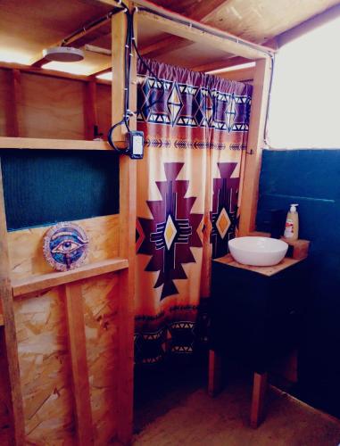 a bathroom with a shower curtain and a sink at Hostel con huerta en la montaña in San José del Cabo
