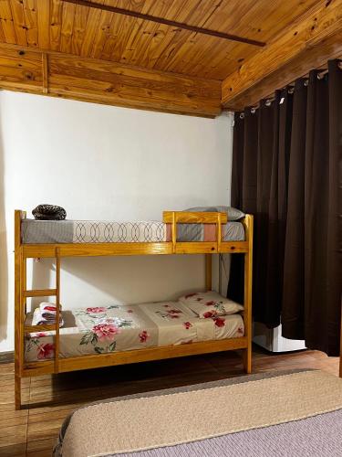 two bunk beds in a room with a wooden ceiling at Guazú Departamentos in Puerto Iguazú