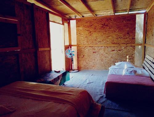 a bedroom with a bed and a fan in a room at Hostel con huerta en la montaña in San José del Cabo