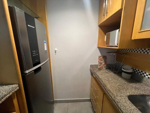 a small kitchen with a refrigerator and a sink at Hotel Flat Moema UH 715 in Sao Paulo