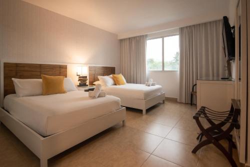 a hotel room with two beds and a couch at Beach Apartment At Nikki Residences 2 Bedroom in El Chirú