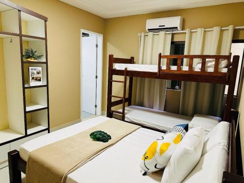 1 Schlafzimmer mit 2 Etagenbetten und einem Sofa in der Unterkunft Casa luxo beira mar 5 qtos e piscina in Tamandaré