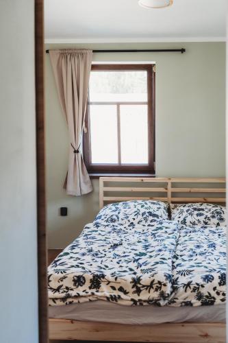 a bedroom with a bed and a window at Apartmány Borovice in Josefŭv Dŭl