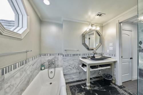 a bathroom with a tub and a sink at Houston Towers Inn, Adults-Only, Downtown, Med Ctr, NRG in Houston