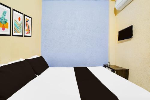 a bedroom with a white bed and a tv at SPOT ON Hotal Krishna in Dīp