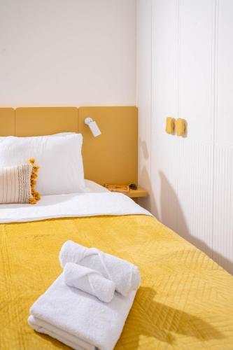 プリシュティナにあるSapling Apartmentのタオルが敷かれたベッドのある寝室