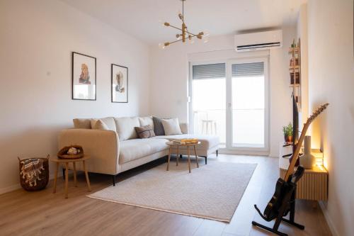 プリシュティナにあるSapling Apartmentのソファとテーブルのあるリビングルーム