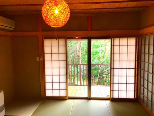 an empty room with a window and a chandelier at THE HIGHEST VILLA IZUMI - Vacation STAY 16413v in Nakatsugawa