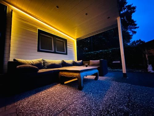 a couch sitting on the side of a house at Ons Schatje op 5-sterren vakantiepark De Schatberg in Sevenum