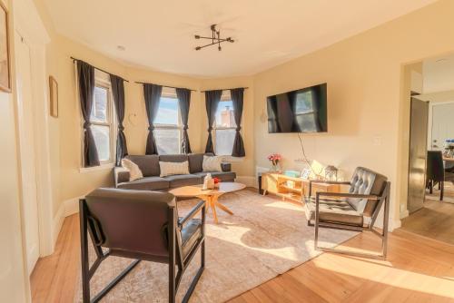a living room with a couch and a table and chairs at LUXE 4BDR2BA Near Boston- T-Station & Encore Casino in Somerville