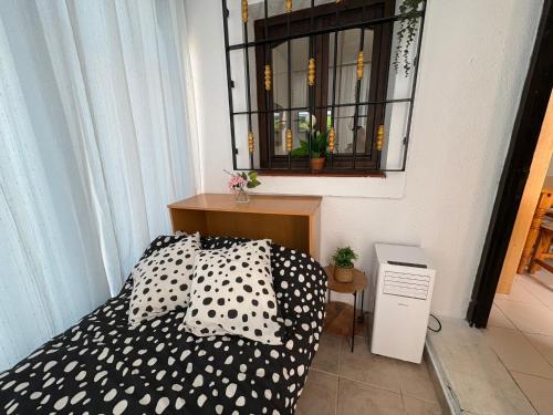 Un dormitorio con una cama con almohadas blancas y negras. en Perfect pool Bungalow HMWY, en Torrevieja