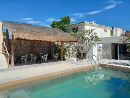 a villa with a swimming pool and a building at Casa Flores de Mayo in Chicxulub